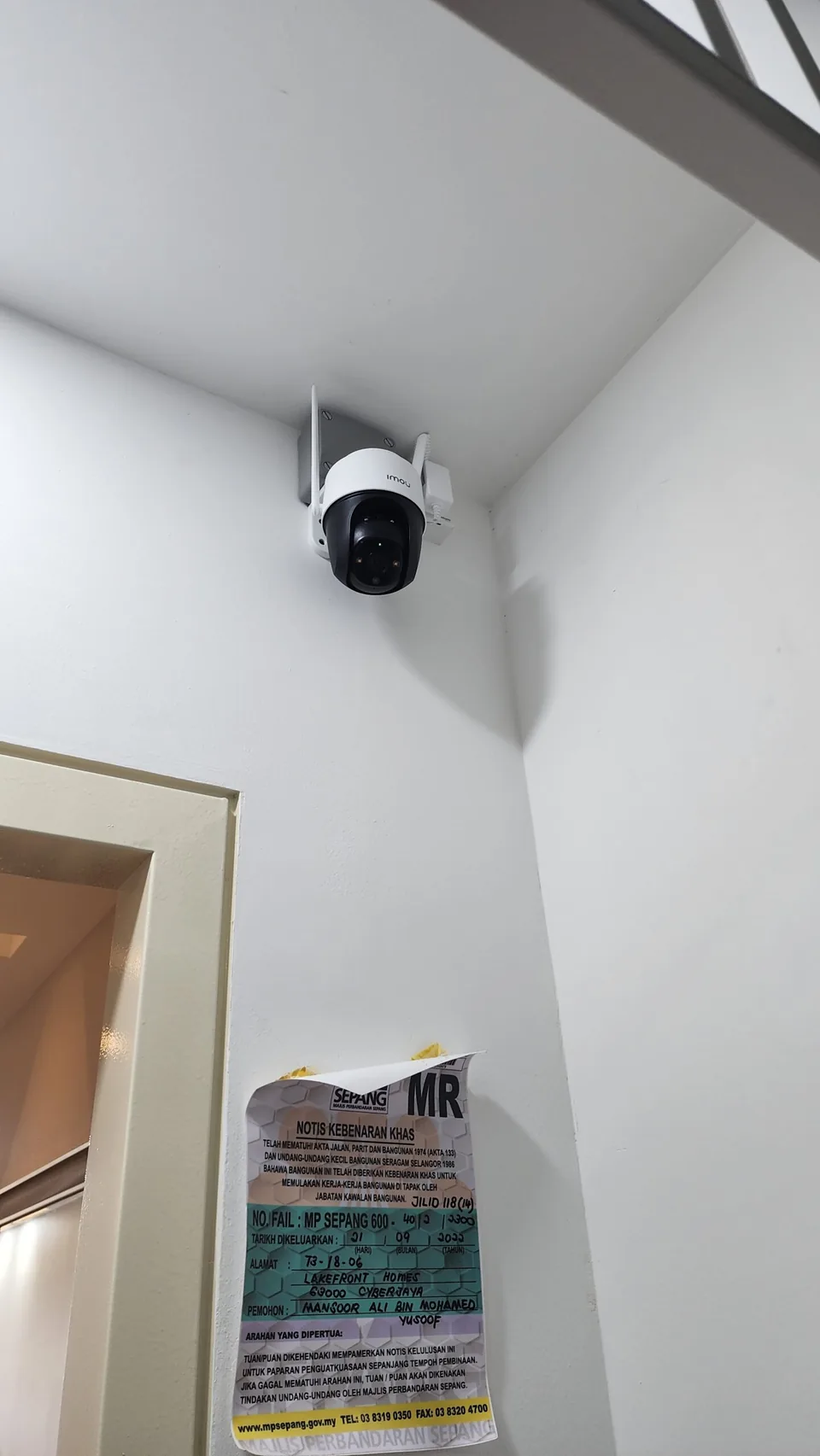 Indoor camera mounted high near a doorway.