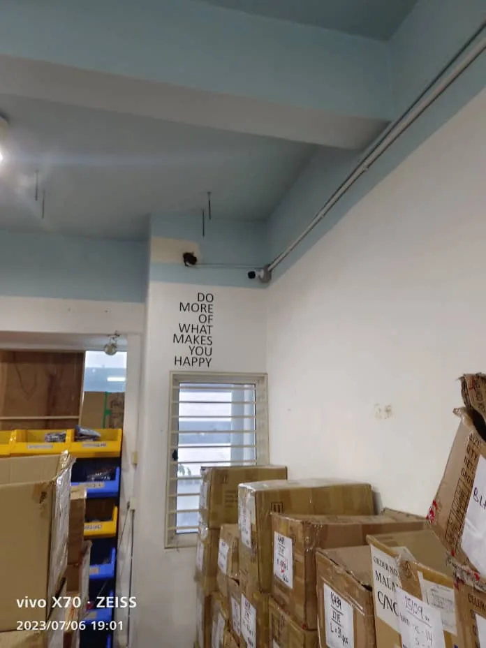 Cabling routed near the ceiling above boxes and shelving.