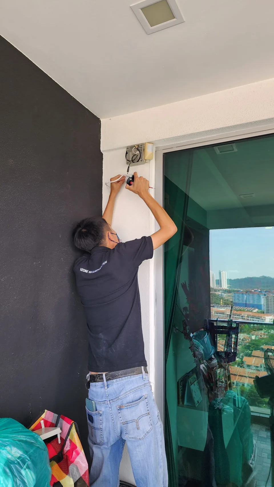 Technician fastening a camera beside a window.