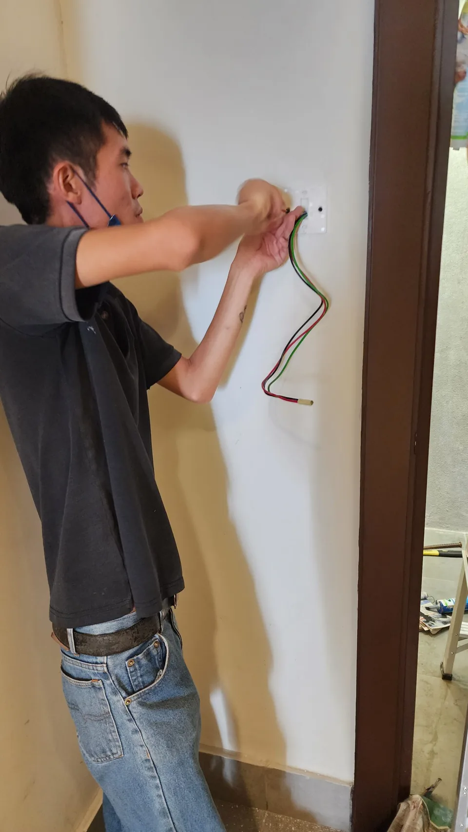 Technician preparing wiring for a wall-mounted access reader.