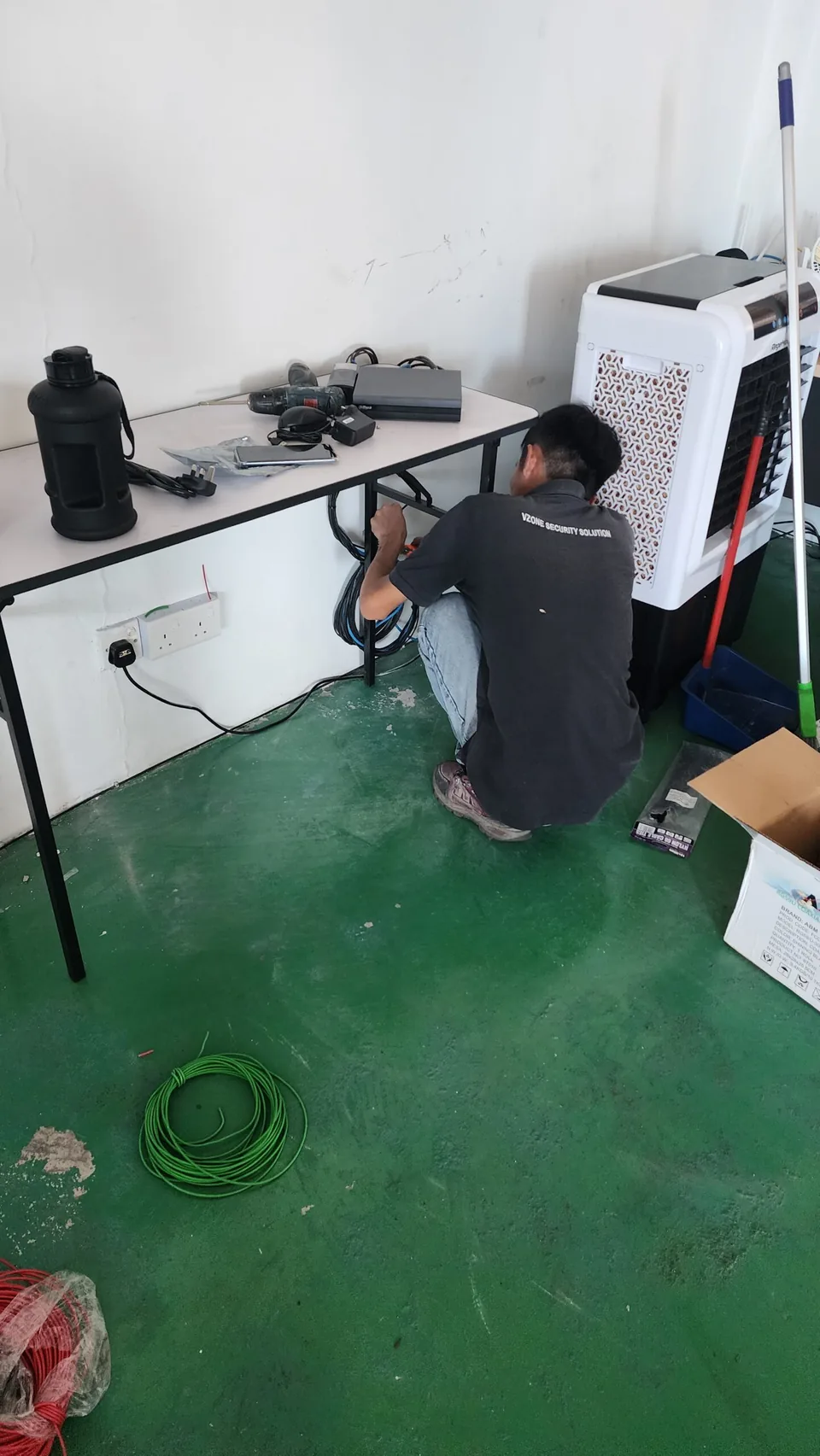 Technician prepares wiring beside equipment on a workbench.