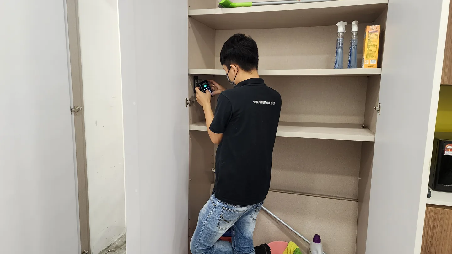 Technician wiring an access-control unit inside a shelving recess.