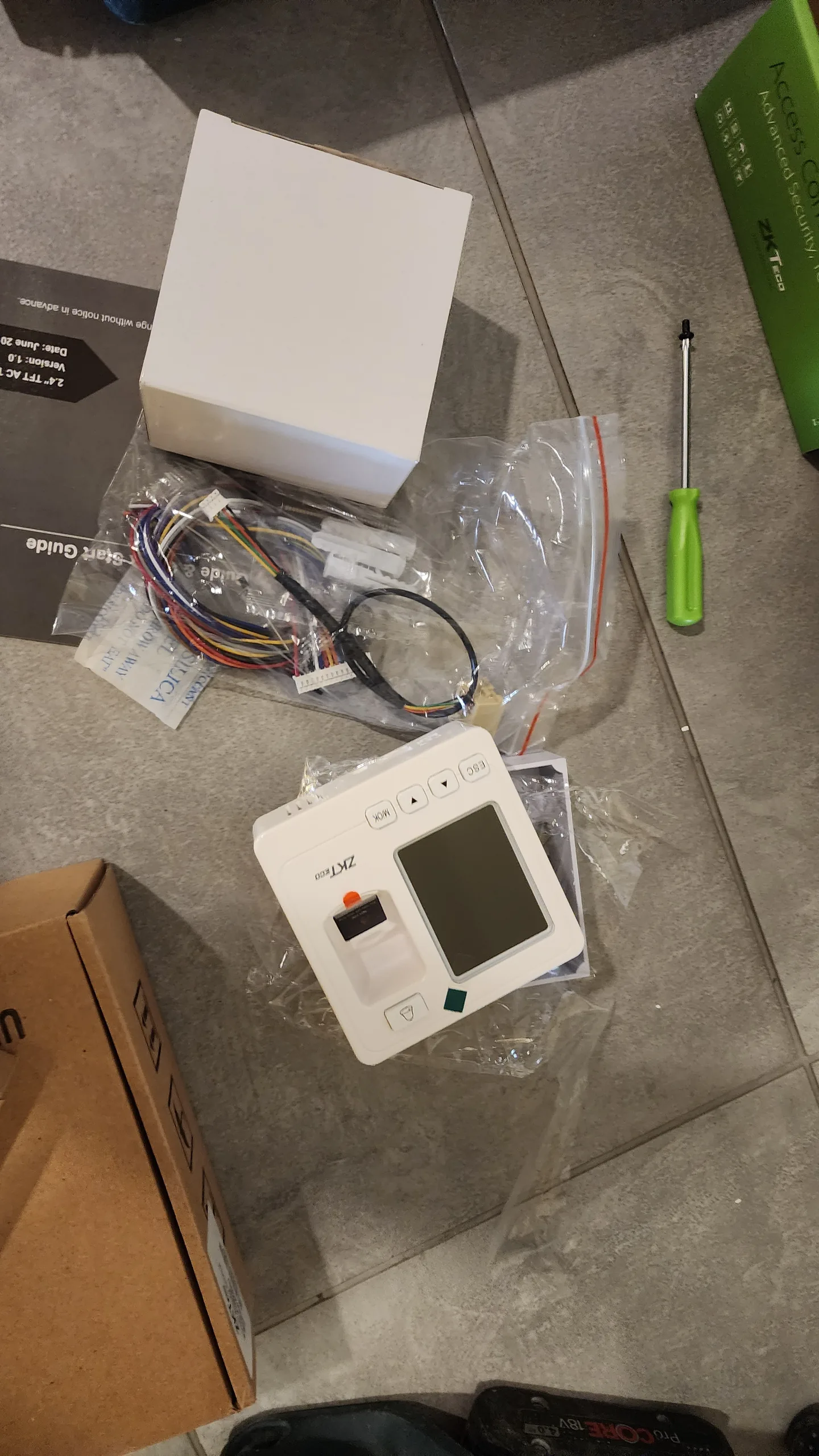 Access-control components, wiring, and tools laid on the floor.